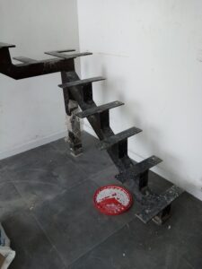 Primer plano de la estructura metálica en zigzag para una escalera interior, lista para recibir las huellas de los escalones.