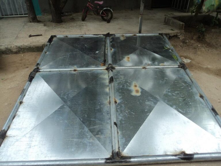 Bastidor de tubos metálicos con láminas de zinc galvanizadas ensambladas para un portón en proceso.